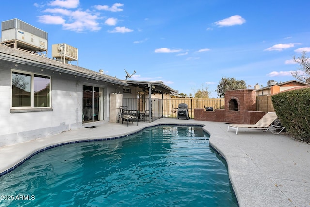 view of swimming pool featuring central AC, a patio, grilling area, and a brick fireplace