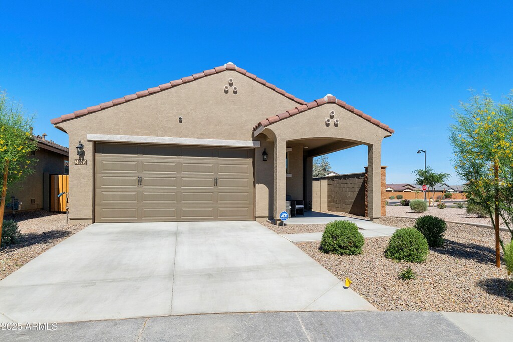 21690 N Lynn St, Maricopa, AZ 85138 - mediterranean / spanish home featuring stucco siding, driveway, a tile roof, and an attached garage