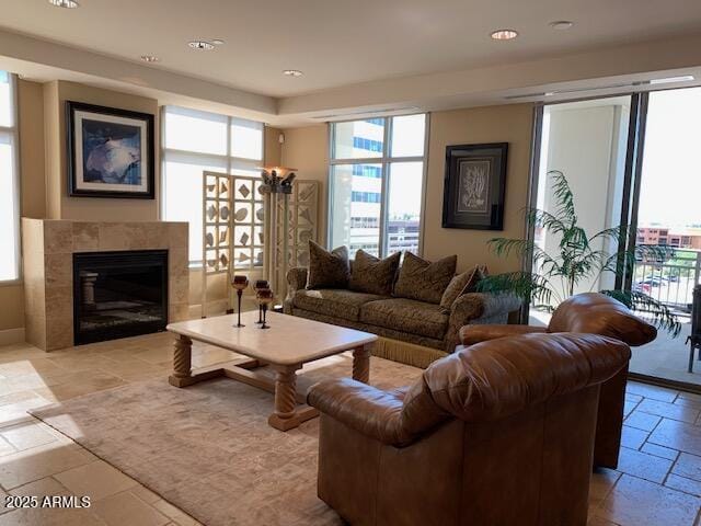 living room featuring a fireplace, stone tile floors, and recessed lighting