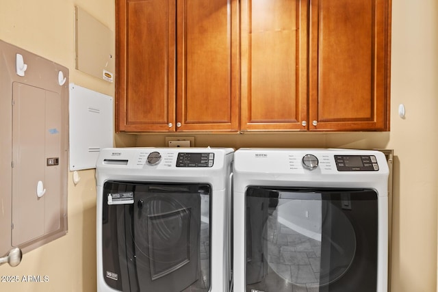 clothes washing area with electric panel, separate washer and dryer, and cabinet space