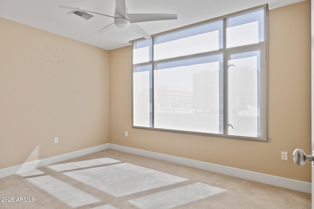 spare room with visible vents, baseboards, a ceiling fan, and carpet