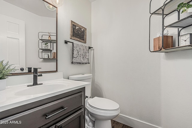 5602 W Alameda Rd, Glendale, AZ 85310 - bathroom with wood finished floors, toilet, vanity, and baseboards