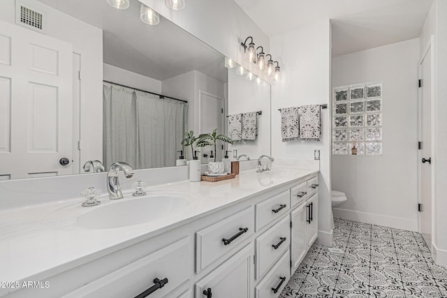 5602 W Alameda Rd, Glendale, AZ 85310 - bathroom with toilet, double vanity, tile patterned floors, and baseboards