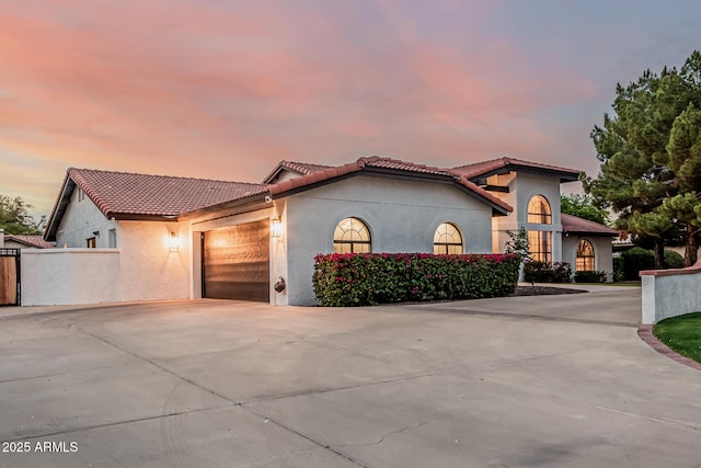 5602 W Alameda Rd, Glendale, AZ 85310 - mediterranean / spanish-style home with stucco siding, concrete driveway, an attached garage, and a tiled roof