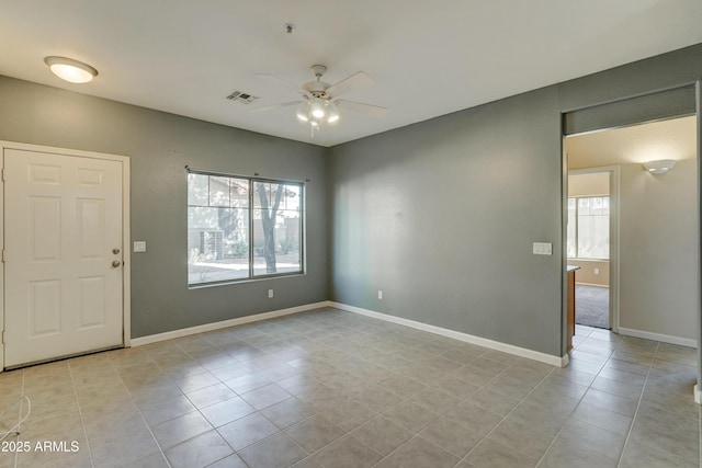 tiled spare room featuring ceiling fan