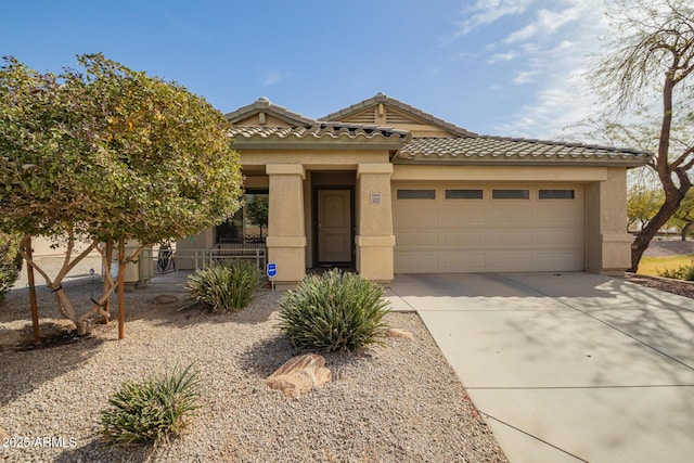 view of front facade featuring a garage, driveway, a tiled roof, and stucco siding