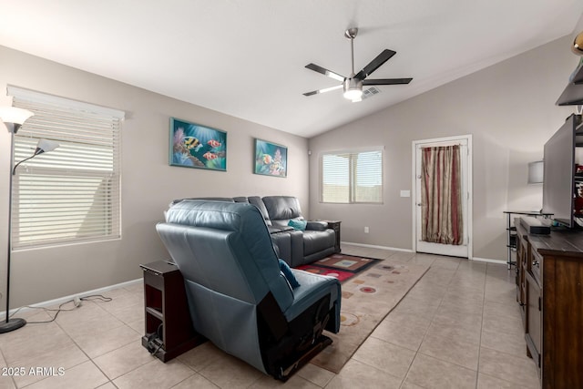 living area with ceiling fan, vaulted ceiling, baseboards, and light tile patterned floors