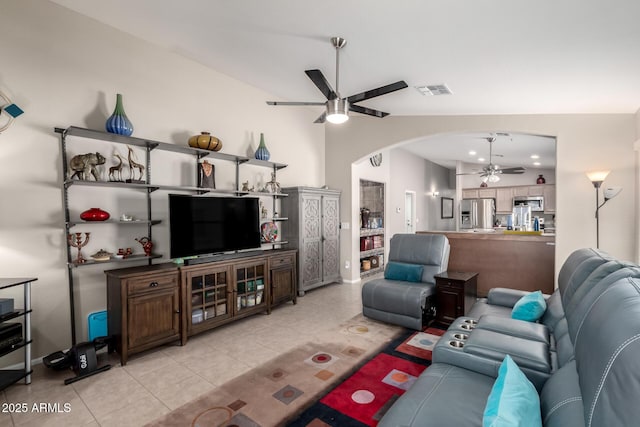 living room with arched walkways, lofted ceiling, visible vents, a ceiling fan, and light tile patterned flooring