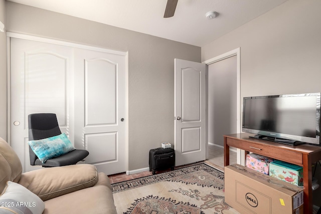 living room featuring light tile patterned floors, ceiling fan, and baseboards