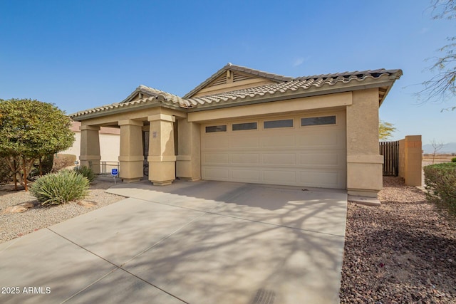 mediterranean / spanish-style house with driveway, a tiled roof, a garage, and stucco siding