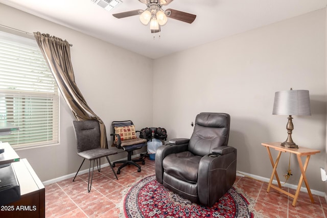 living area with ceiling fan, tile patterned floors, visible vents, and baseboards