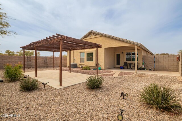 back of house featuring central AC unit, a fenced backyard, stucco siding, a pergola, and a patio area