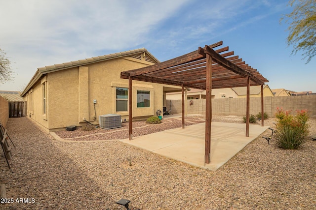 back of house featuring a pergola, a patio area, a fenced backyard, and stucco siding