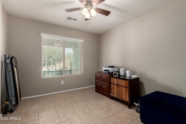 office space with baseboards, visible vents, a ceiling fan, and light tile patterned flooring