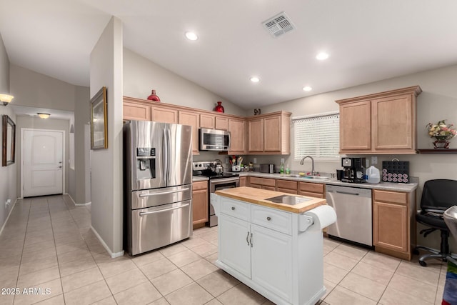 kitchen with a sink, visible vents, vaulted ceiling, appliances with stainless steel finishes, and a center island