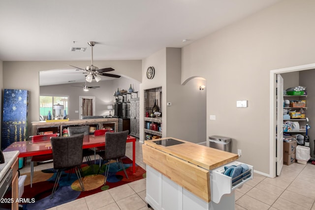 dining space featuring light tile patterned floors, visible vents, arched walkways, lofted ceiling, and ceiling fan