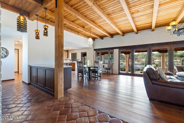 living room featuring a notable chandelier, beam ceiling, wood ceiling, and dark wood-type flooring