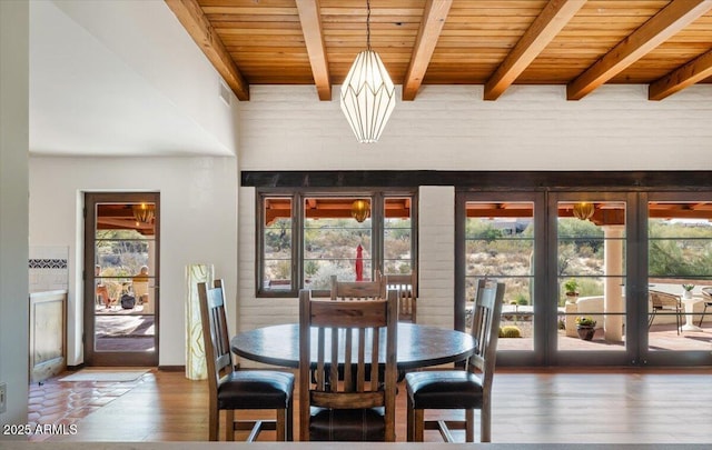 dining room with beam ceiling, a healthy amount of sunlight, and wooden ceiling