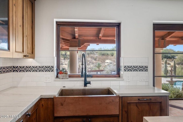 kitchen with backsplash, a healthy amount of sunlight, and sink