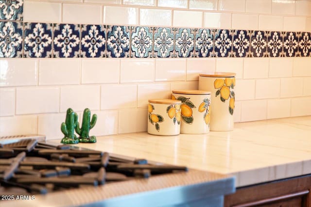 interior details with light stone counters and stainless steel gas cooktop