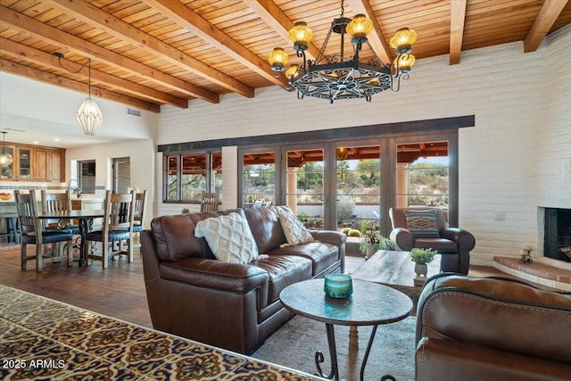 living room featuring beam ceiling, french doors, dark wood-type flooring, wooden ceiling, and a chandelier