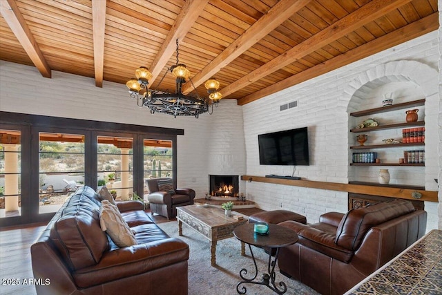 living room with wood ceiling, a large fireplace, beam ceiling, hardwood / wood-style flooring, and a notable chandelier