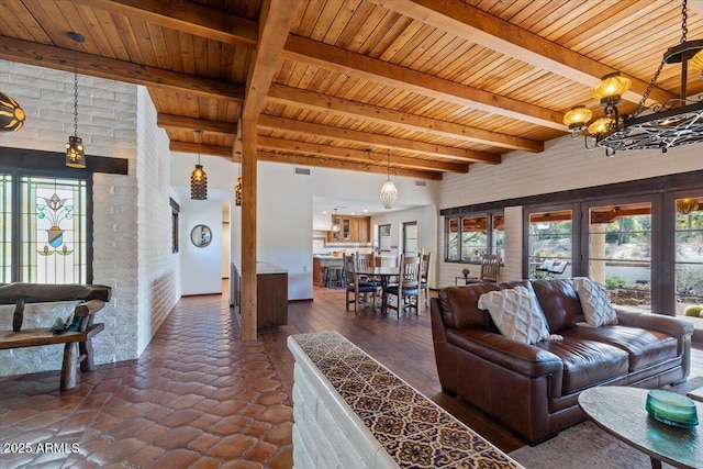 living room featuring beam ceiling, wooden ceiling, brick wall, and a notable chandelier