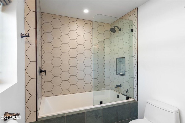 bathroom featuring toilet and tiled shower / bath