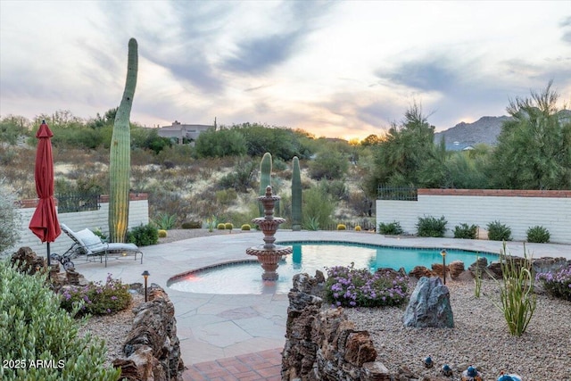 pool at dusk with a patio