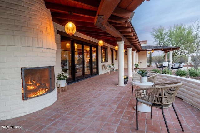 patio terrace at dusk with an outdoor fireplace