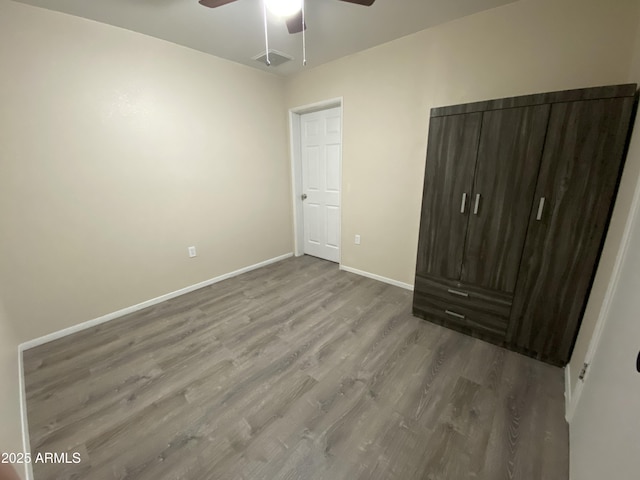 unfurnished bedroom featuring wood-type flooring and ceiling fan