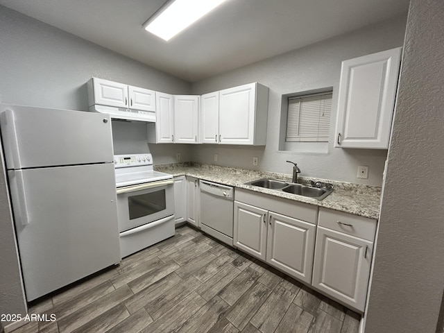 kitchen with dark hardwood / wood-style flooring, sink, white cabinets, and white appliances