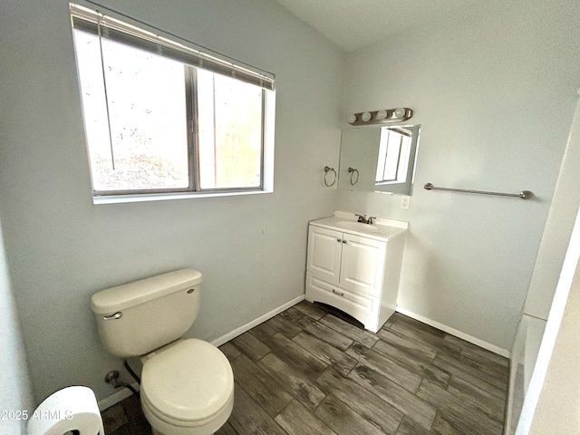 bathroom featuring vanity, a healthy amount of sunlight, toilet, and wood-type flooring