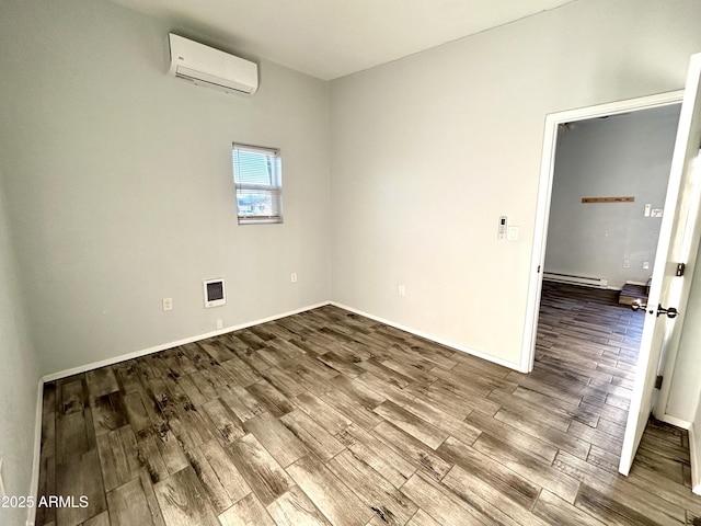 spare room featuring a wall mounted air conditioner, hardwood / wood-style floors, and a baseboard heating unit