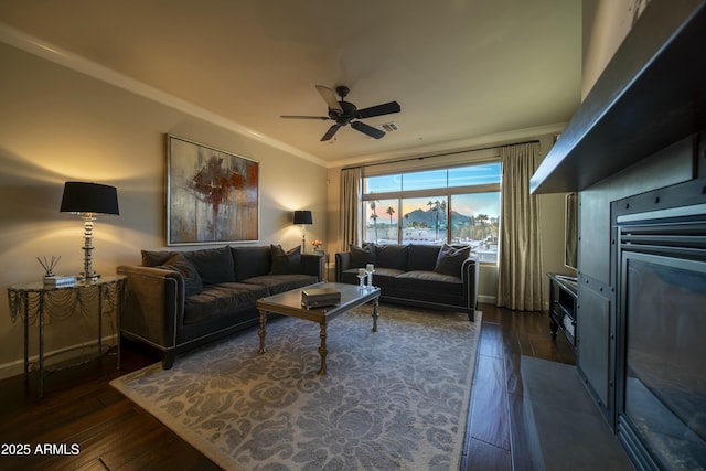 living room with ceiling fan, crown molding, and dark hardwood / wood-style flooring