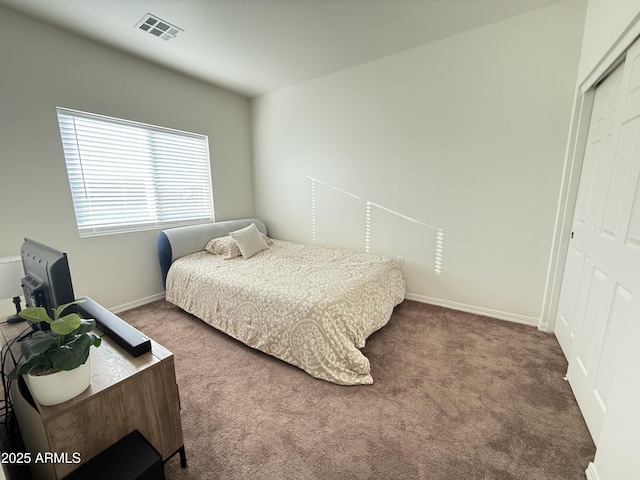 bedroom with carpet floors, baseboards, visible vents, and a closet