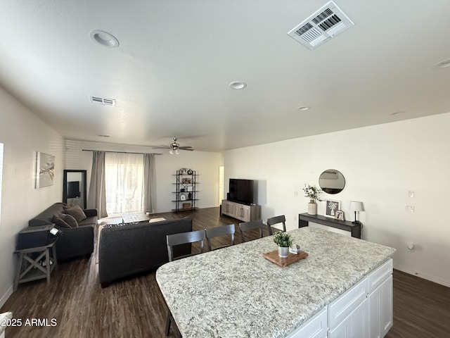 dining room with baseboards, visible vents, and dark wood-style flooring