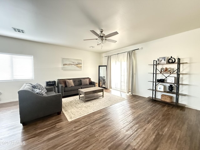 living area featuring a ceiling fan, dark wood-style flooring, visible vents, and baseboards