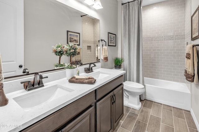 bathroom featuring double vanity, shower / tub combo, toilet, and a sink