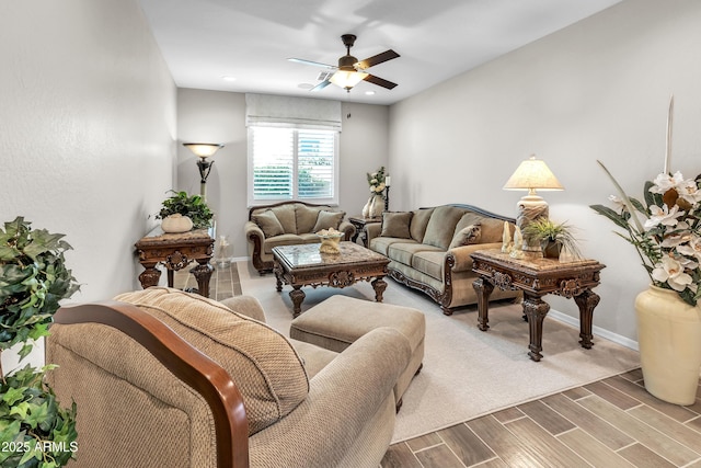 living area with baseboards, a ceiling fan, and wood finished floors