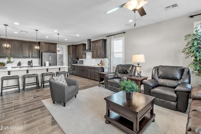 living area with recessed lighting, light wood-style floors, visible vents, and ceiling fan