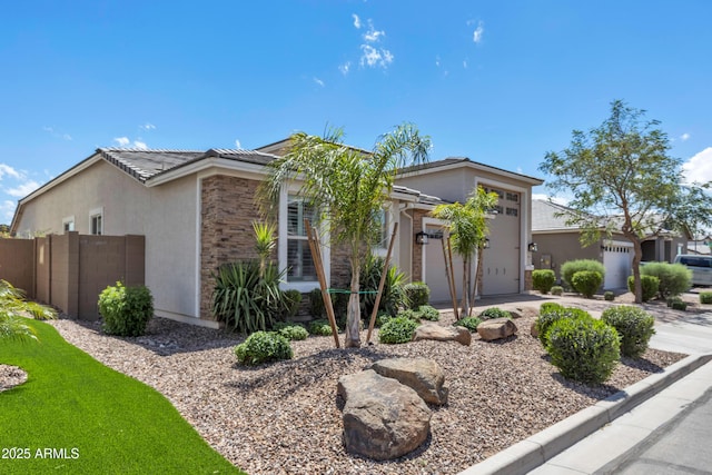 view of front of home featuring a tiled roof, concrete driveway, fence, an attached garage, and stucco siding