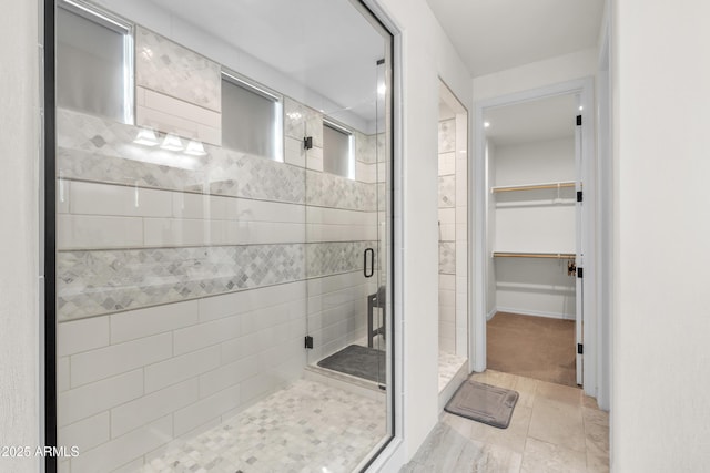full bath with a shower stall and a walk in closet