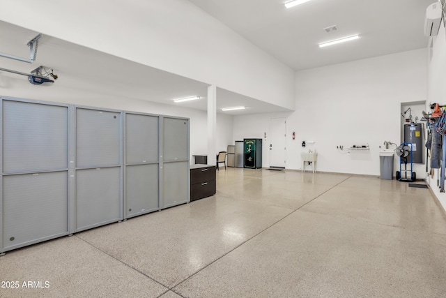 garage featuring a wall mounted AC, visible vents, a sink, and electric water heater
