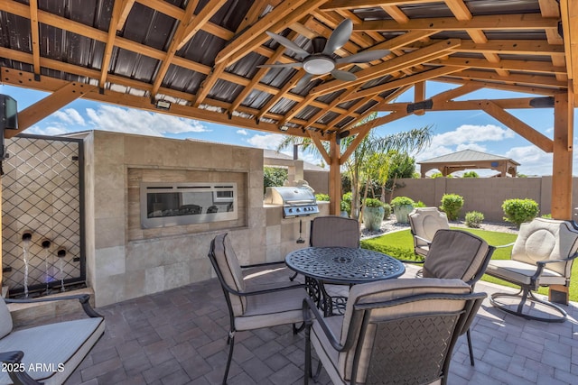 view of patio with a gazebo, a ceiling fan, fence private yard, grilling area, and an outdoor kitchen
