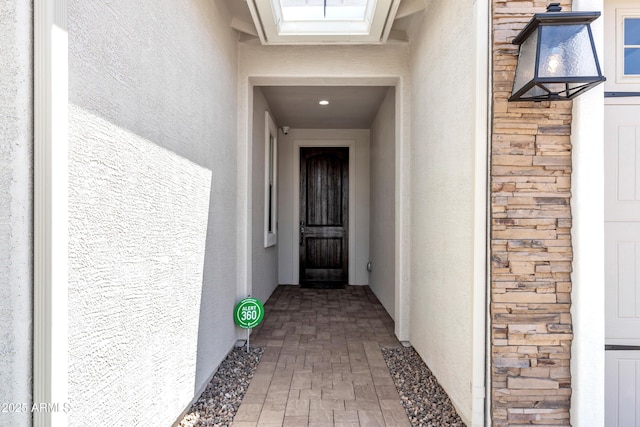 view of exterior entry with stucco siding