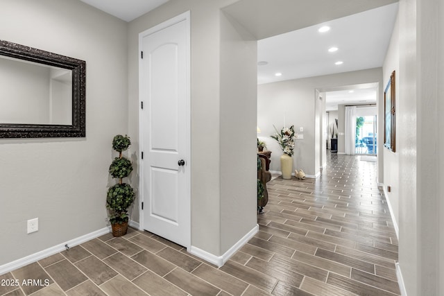 hall featuring baseboards, wood finish floors, and recessed lighting
