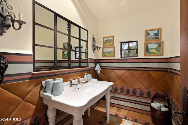 bathroom featuring a wainscoted wall and tile walls