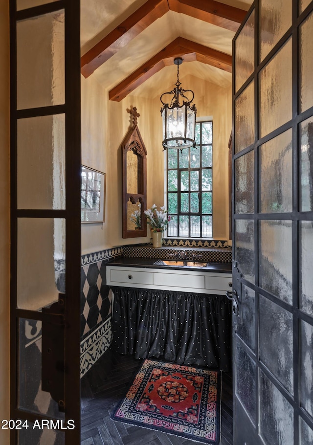 bathroom featuring a notable chandelier and vaulted ceiling with beams