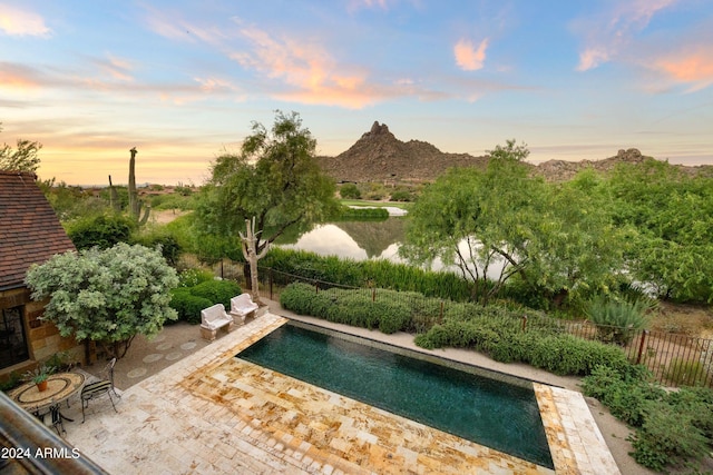 view of pool featuring a mountain view, a patio, a fenced in pool, and fence